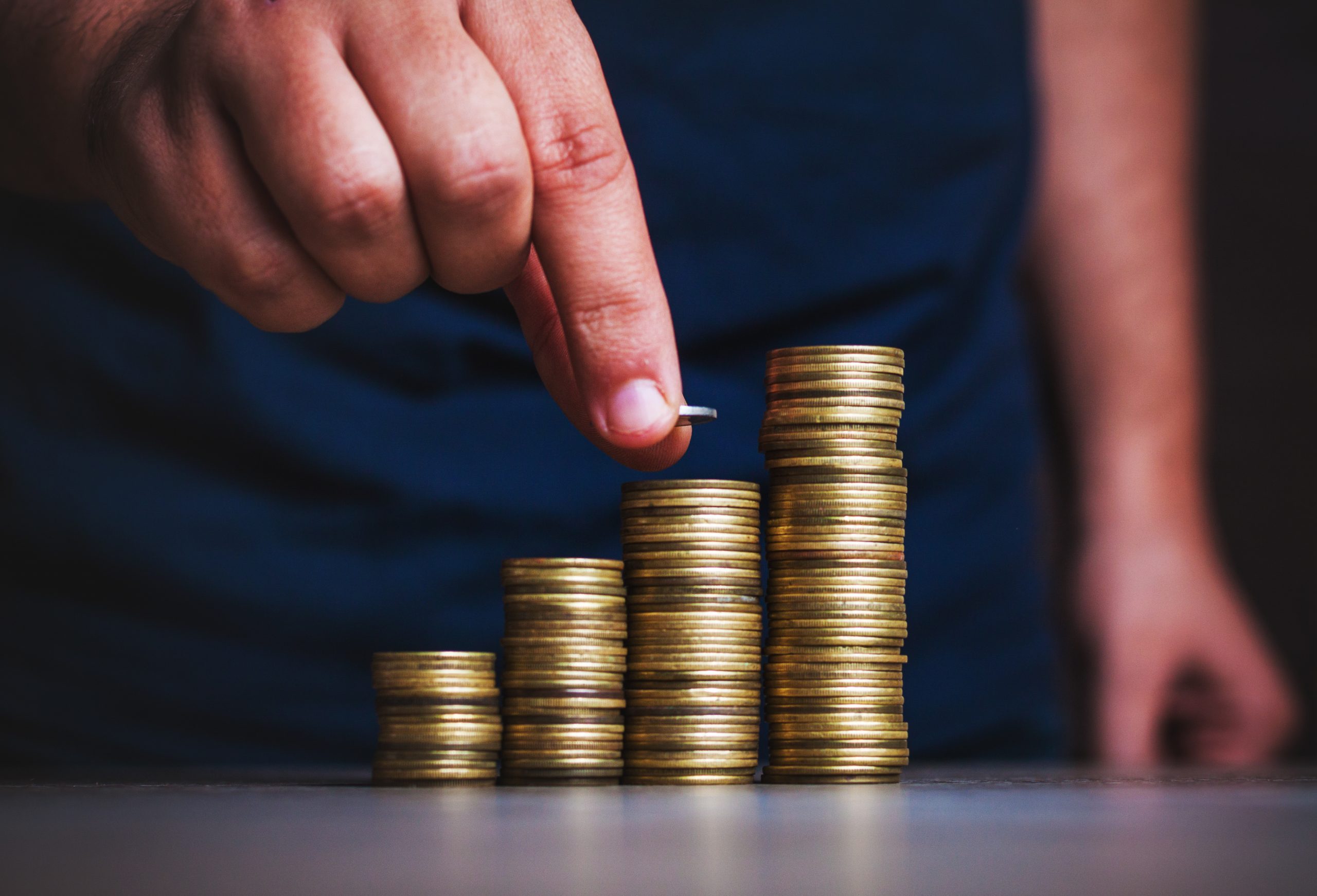 Man's hand put money coins to stack of coins. Money, Financial, Business Growth concept.